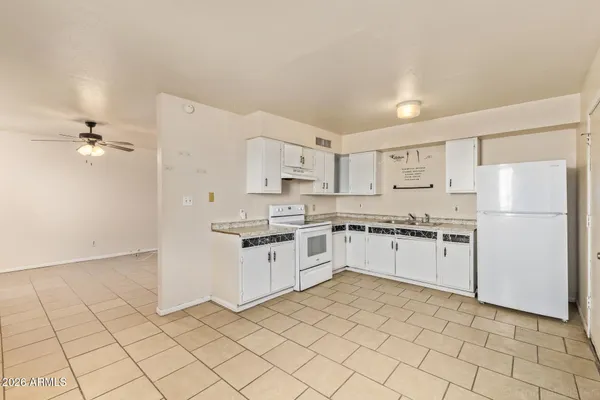 a kitchen with granite countertop white cabinets and white appliances