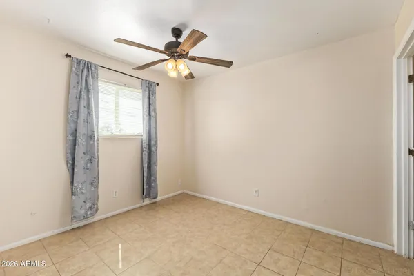 an empty room with windows and fan