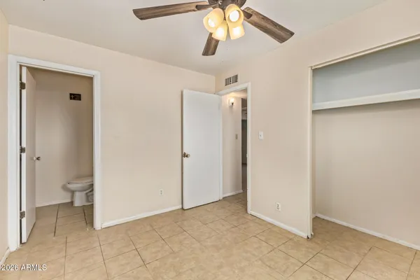 a view of an empty room and chandelier fan