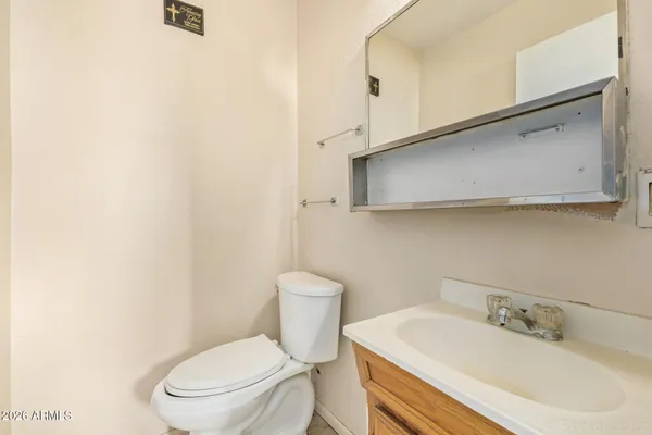 a bathroom with a toilet a sink and mirror