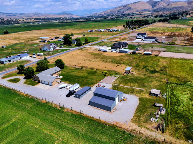 802 East 3200 Road North Preston, ID 83263 - Photo 50 of 59 Expansive rural property featuring multiple structures, including a large gray metal building with white overhead doors, a tan building with multiple garage bays, and an additional tan structure
