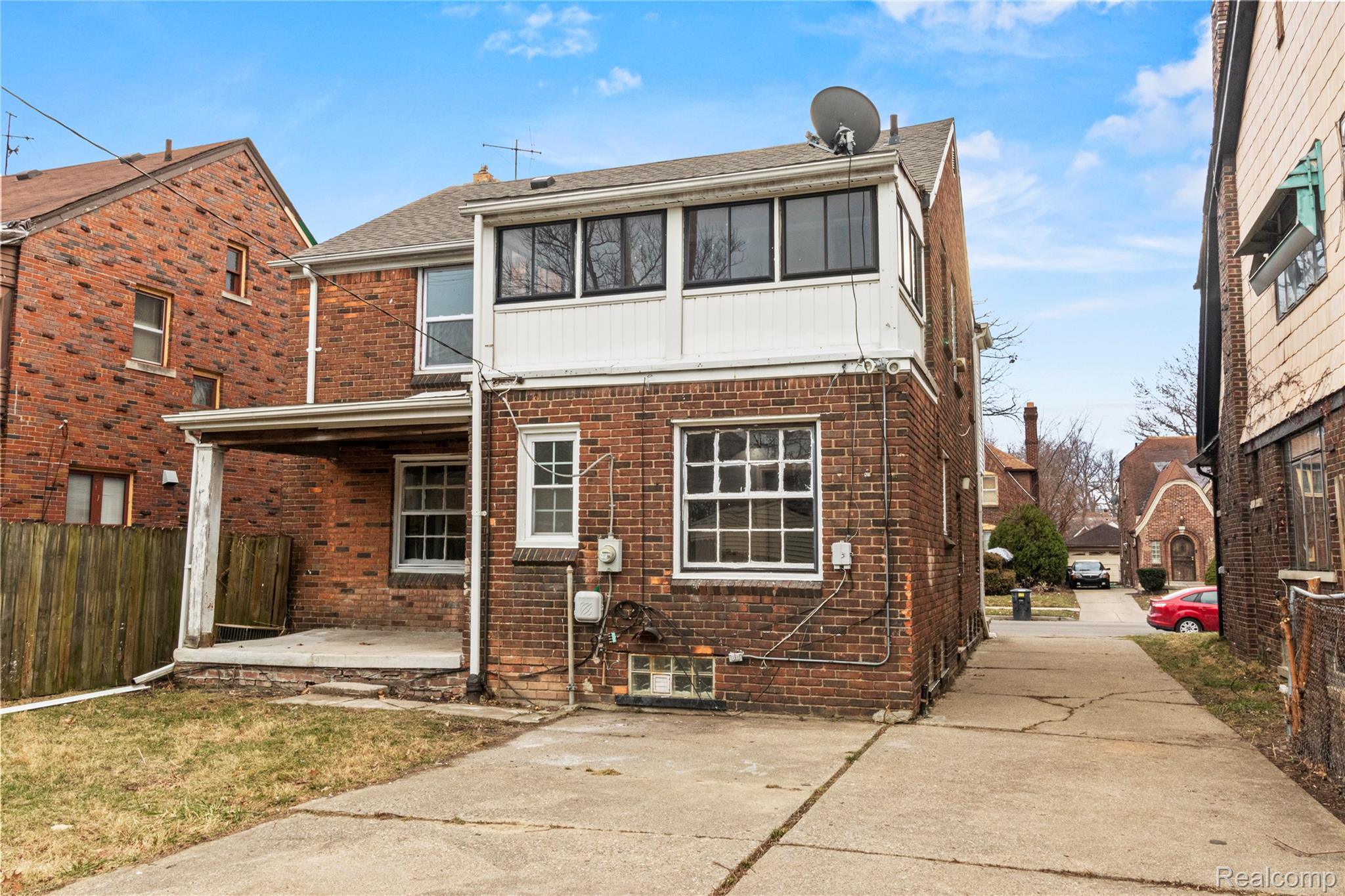 4834 Devonshire Road Detroit, MI 48224 - Photo 22 of 22 Back of property featuring a patio area, brick siding, a shingled roof, and board and batten siding