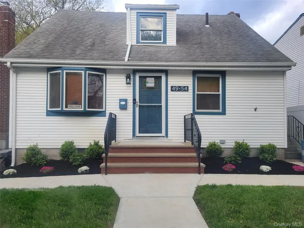 a front view of a house with a garden and plants