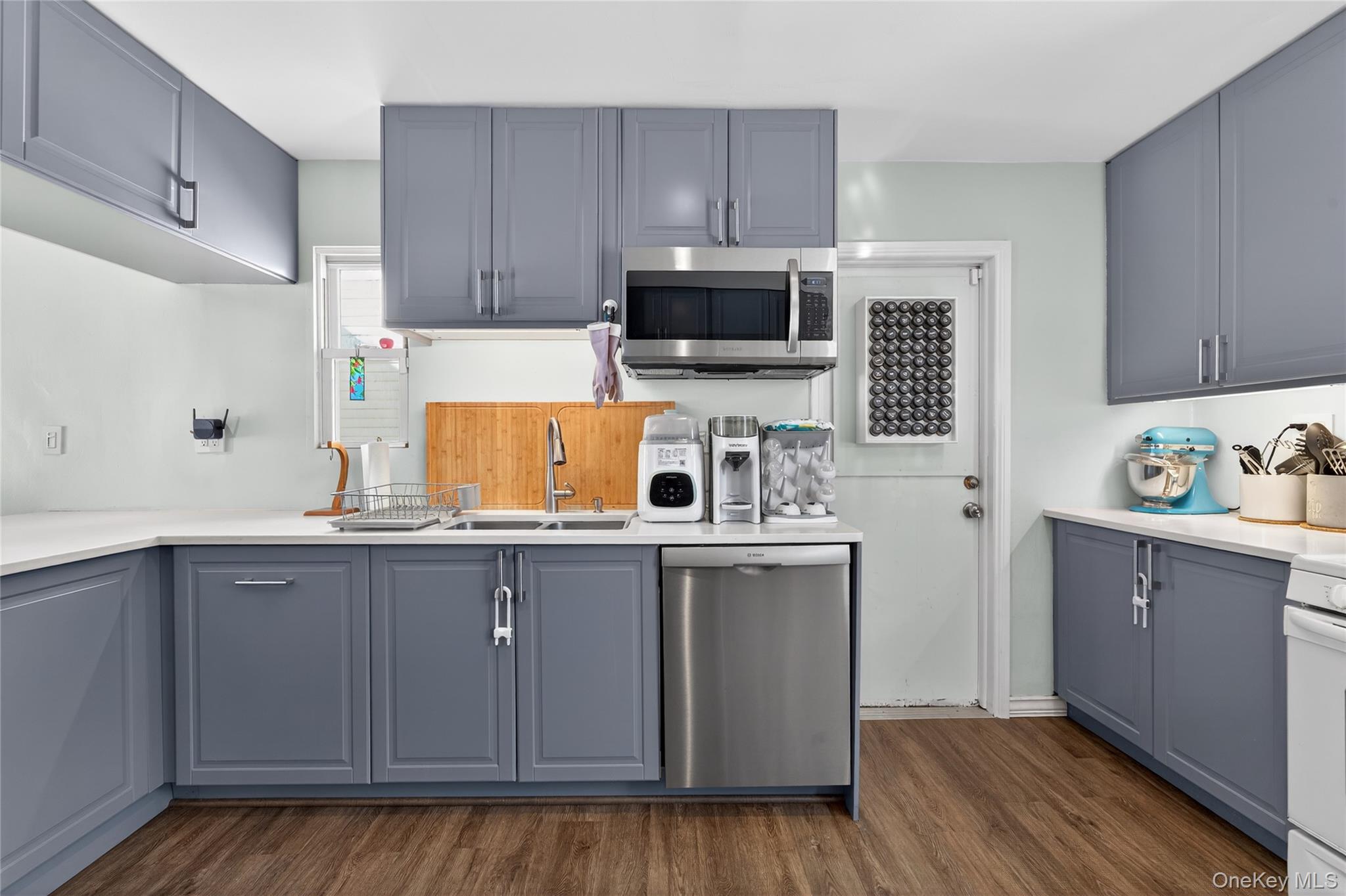 49-54 166th Street Queens, NY 11365 - Photo 24 of 41 a kitchen with stainless steel appliances granite countertop a sink a stove top oven and wooden floors