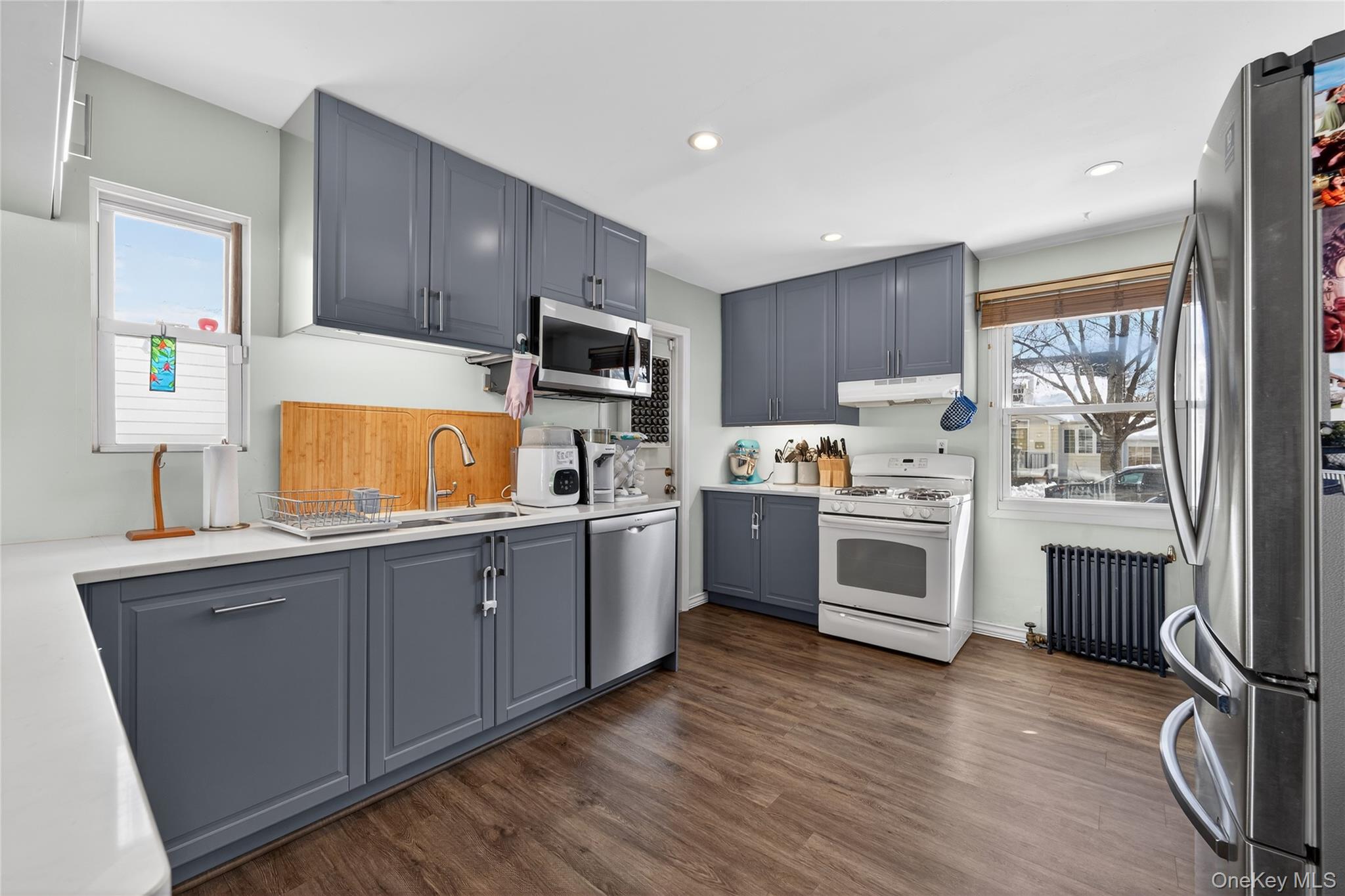 49-54 166th Street Queens, NY 11365 - Photo 25 of 41 a kitchen with granite countertop wooden floors stainless steel appliances and sink