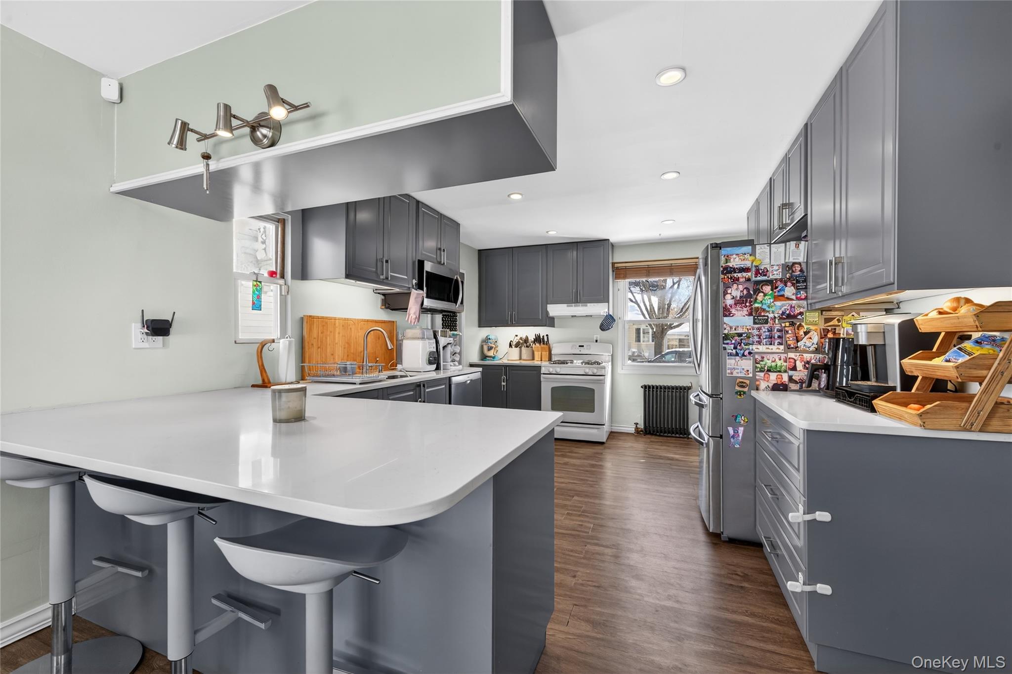 49-54 166th Street Queens, NY 11365 - Photo 26 of 41 a kitchen with stainless steel appliances a table chairs and a refrigerator