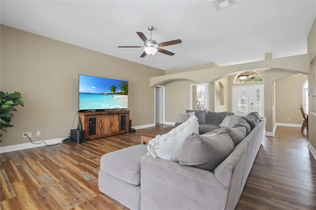 a living room with furniture and a wooden floor