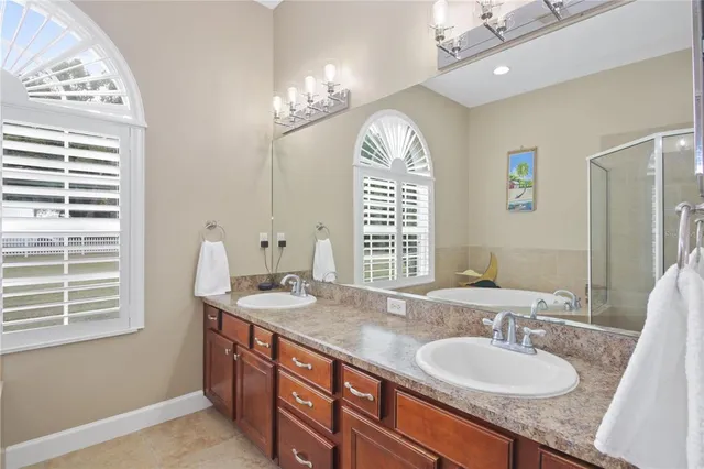 a bathroom with a granite countertop sink a large mirror and a window