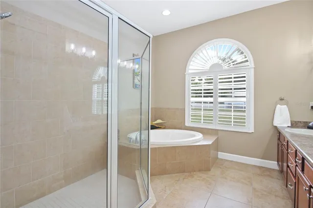 a spacious bathroom with a granite countertop tub a sink and a large mirror
