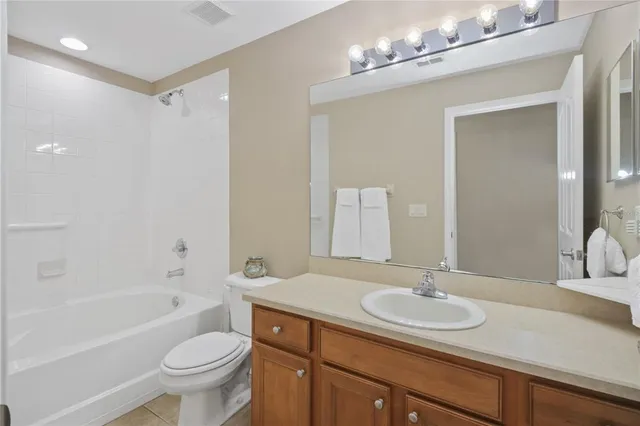 a bathroom with a sink a toilet a mirror a bathtub and shower
