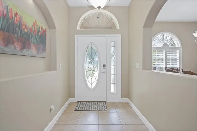 an empty room with windows mirror and fan