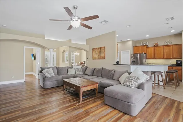 a living room with furniture and a view of kitchen