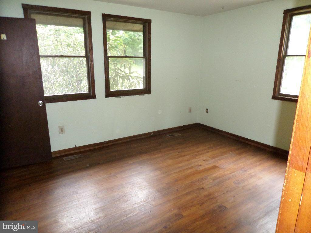 4242 Roop Road Mount Airy, MD 21771 - Photo 6 of 14 an empty room with wooden floor and windows
