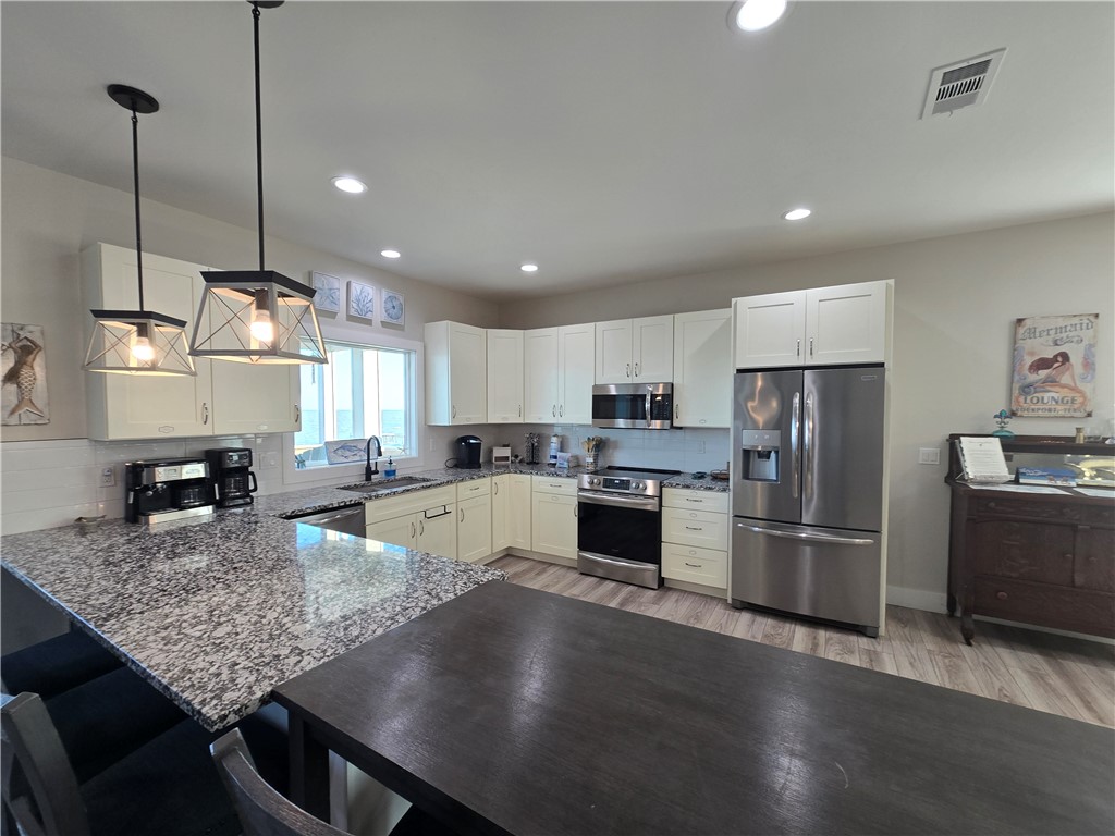 122 Ridge Harbor Drive Rockport, TX 78382 - Photo 18 of 34 a kitchen with refrigerator a stove and wooden floor