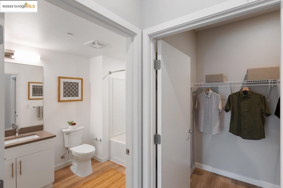 260 Brooklyn Basin Way, Unit 417 Oakland, CA 94606 - Photo 16 of 48 Full bathroom featuring light wood finished floors, vanity, and shower combination