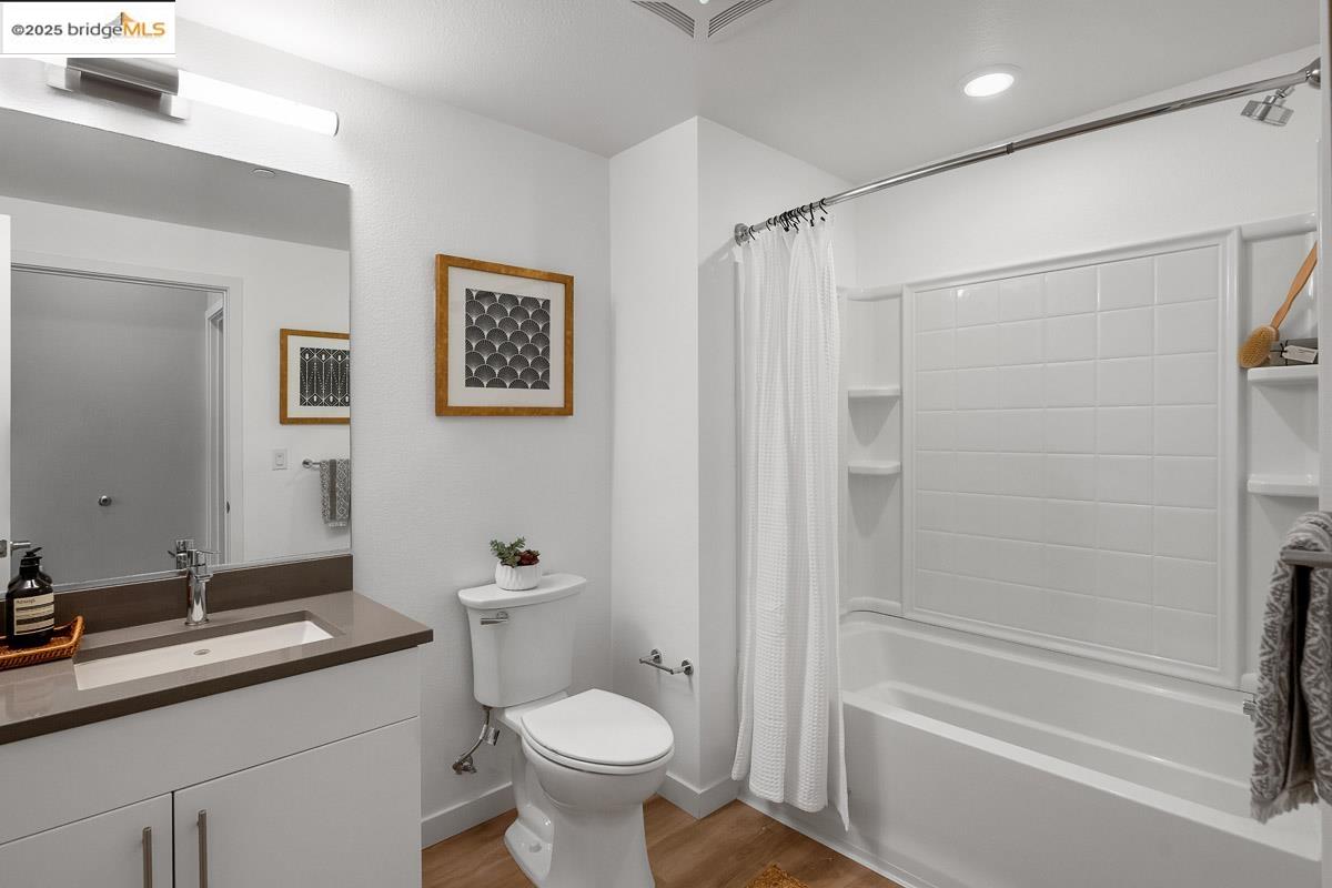 260 Brooklyn Basin Way, Unit 417 Oakland, CA 94606 - Photo 17 of 48 Bathroom featuring shower / bath combination with curtain, light wood finished floors, vanity, and recessed lighting