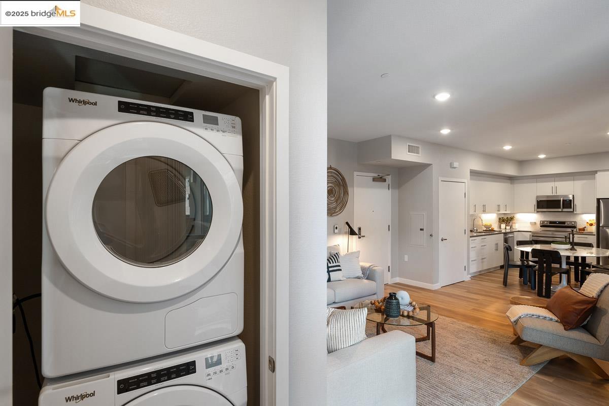 260 Brooklyn Basin Way, Unit 417 Oakland, CA 94606 - Photo 18 of 48 Laundry area with light wood-style flooring, estacked washer and dryer, and recessed lighting