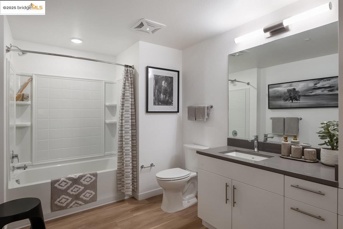 260 Brooklyn Basin Way, Unit 417 Oakland, CA 94606 - Photo 21 of 48 Full bathroom featuring shower / tub combo with curtain, light wood-style flooring, and vanity