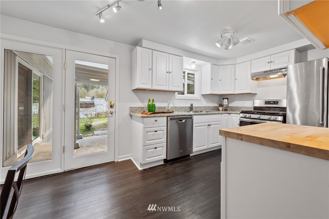 3309 Southeast 5th Street Renton, WA 98058 - Photo 14 of 23 a kitchen with stainless steel appliances white cabinets and wooden floors