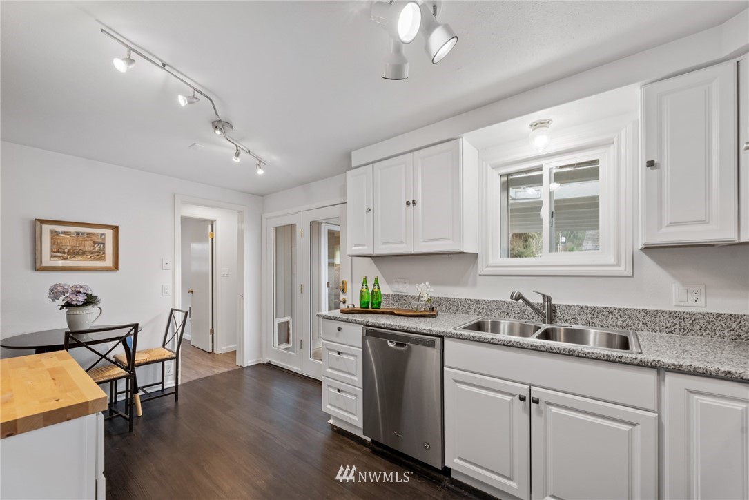 3309 Southeast 5th Street Renton, WA 98058 - Photo 15 of 23 a kitchen with stainless steel appliances kitchen island granite countertop a sink cabinets and wooden floor