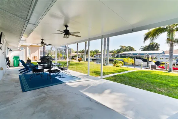 a view of a dining room with furniture one side kitchen view and wooden floor