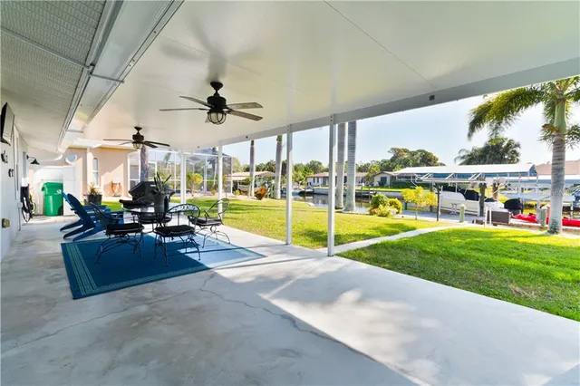 a view of a dining room with furniture one side kitchen view and wooden floor