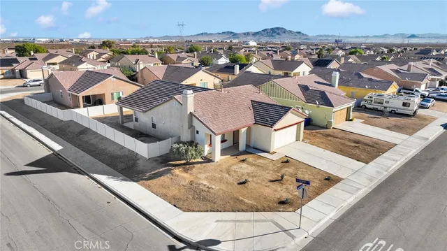 an aerial view of a house with a swimming pool and mountains