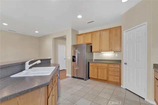 a kitchen with a sink refrigerator and cabinets