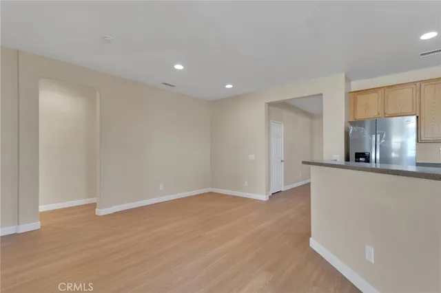 a view of kitchen with stainless steel appliances wooden floor and window