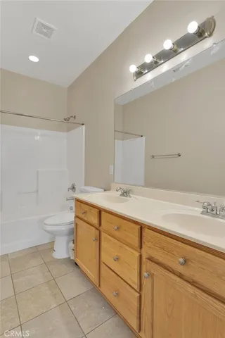 a bathroom with a granite countertop sink a toilet and a bathtub