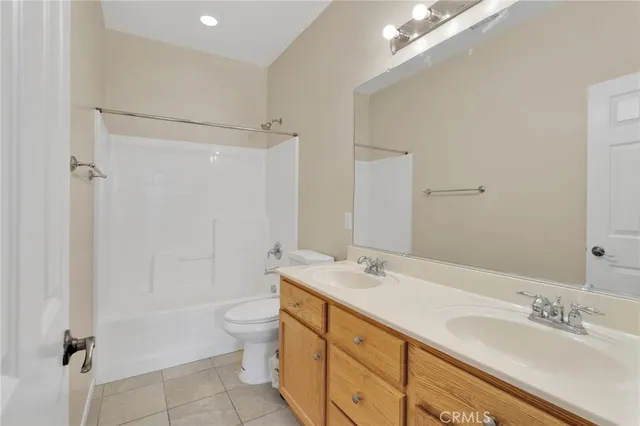 a bathroom with a double vanity sink toilet mirror and shower