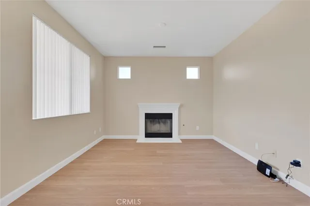 a view of an empty room with a fireplace and a window