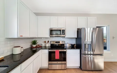 a dining room with stainless steel appliances a dining table and chairs