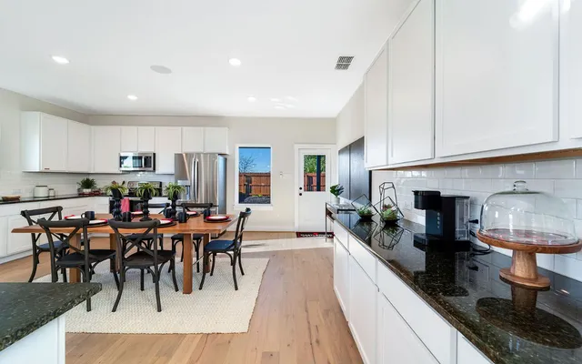 a living room with furniture kitchen view and a chandelier