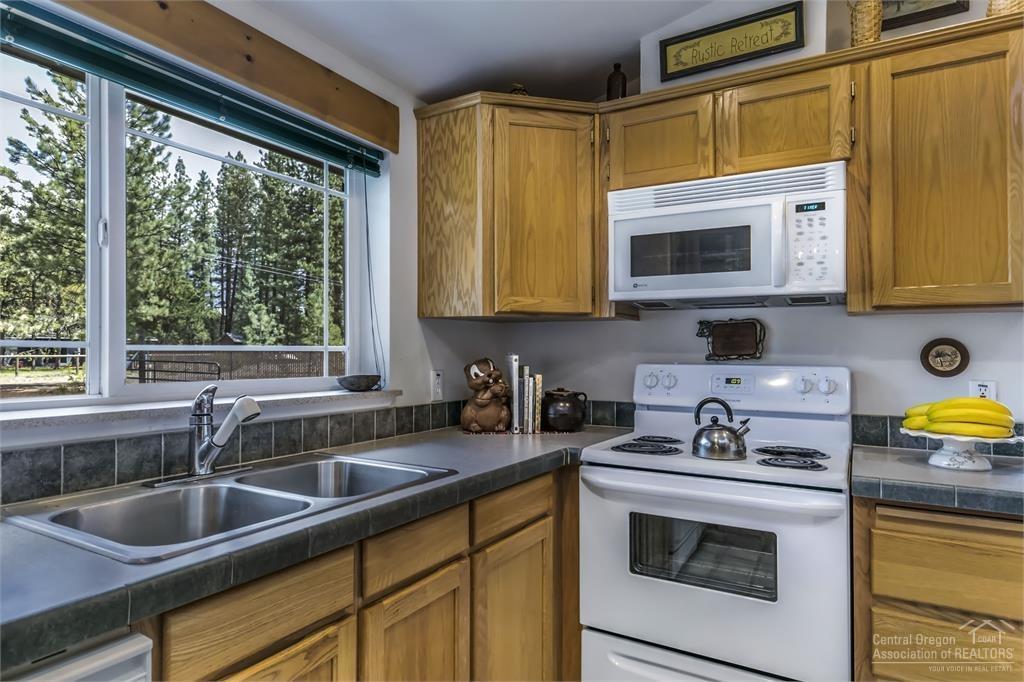 17171 Island Loop Way Bend, OR 97707 - Photo 7 of 25 a kitchen with a sink stove and microwave