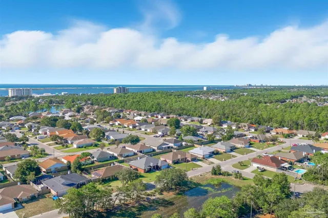 an empty room with wooden floor fireplace and windows