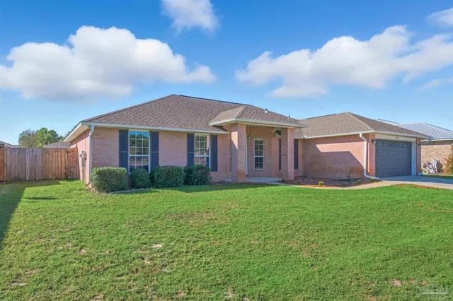 a view of a yard in front of a house with large tree