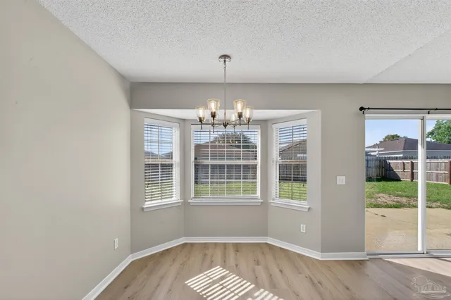 a view of an empty room with wooden floor and closet