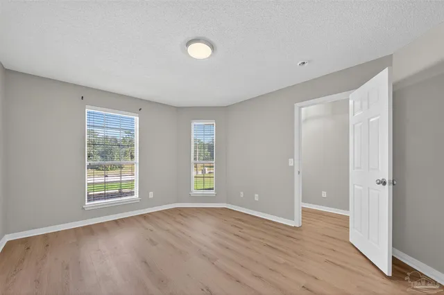 a view of an empty room with wooden floor