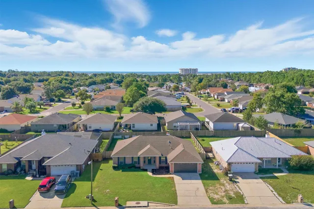 an aerial view of a city with lots of residential buildings and mountain view in back