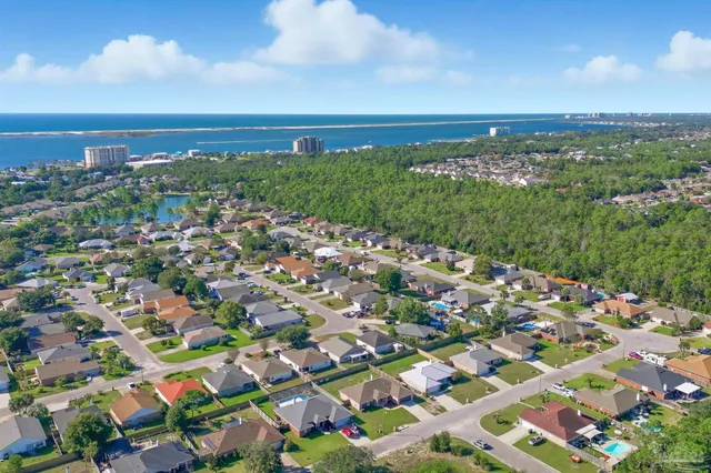 a view of a hallway with wooden floor and a bathroom