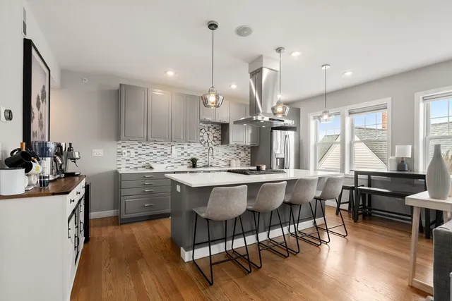a kitchen with a dining table chairs sink and wooden floor
