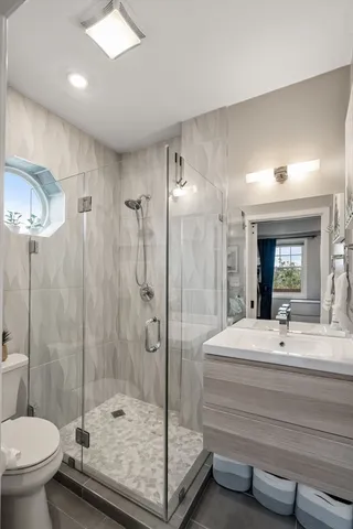 a bathroom with a double vanity sink toilet and shower