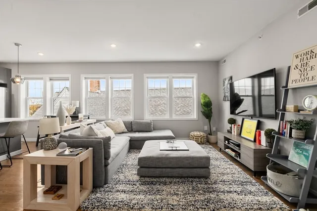 a living room with furniture large window and a flat screen tv