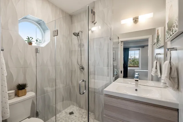 a bathroom with a sink a toilet and shower