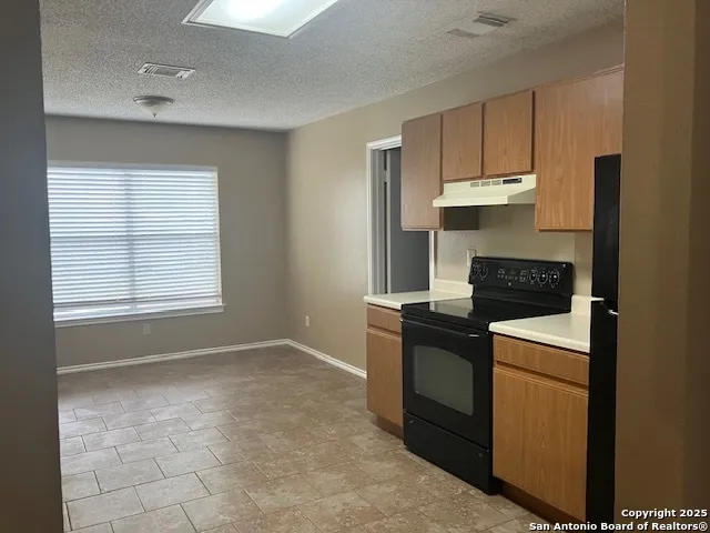 a kitchen with stainless steel appliances granite countertop a stove and a refrigerator