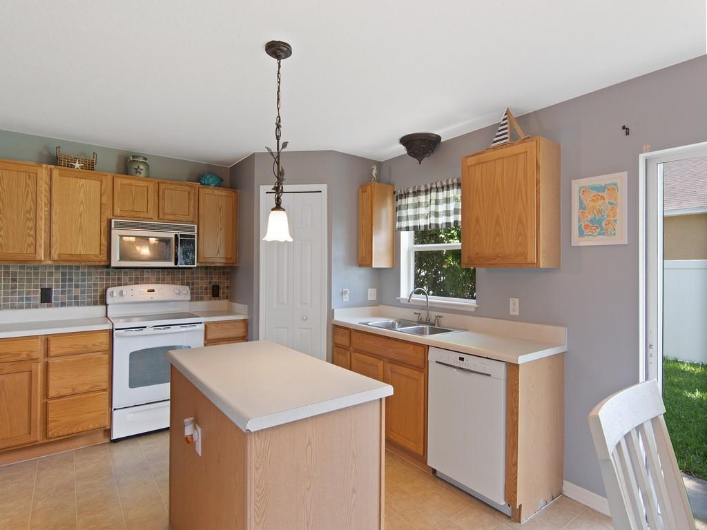 5985 Ridge Lake Circle Vero Beach, FL 32967 - Photo 7 of 27 a kitchen with a sink stove and refrigerator