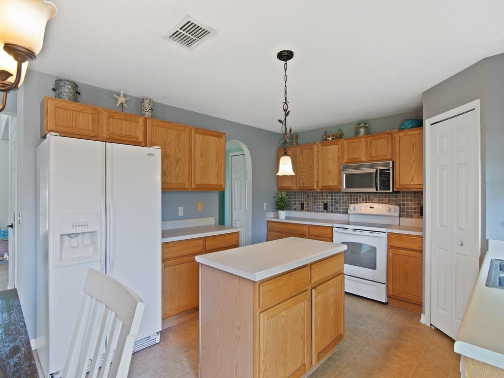 5985 Ridge Lake Circle Vero Beach, FL 32967 - Photo 8 of 27 a kitchen with a refrigerator a sink a stove and cabinets