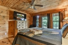 101 Moonshine Mountain Road Mineral Bluff, GA 30559 - Photo 18 of 70 a bedroom with a bed next to a window with outer view