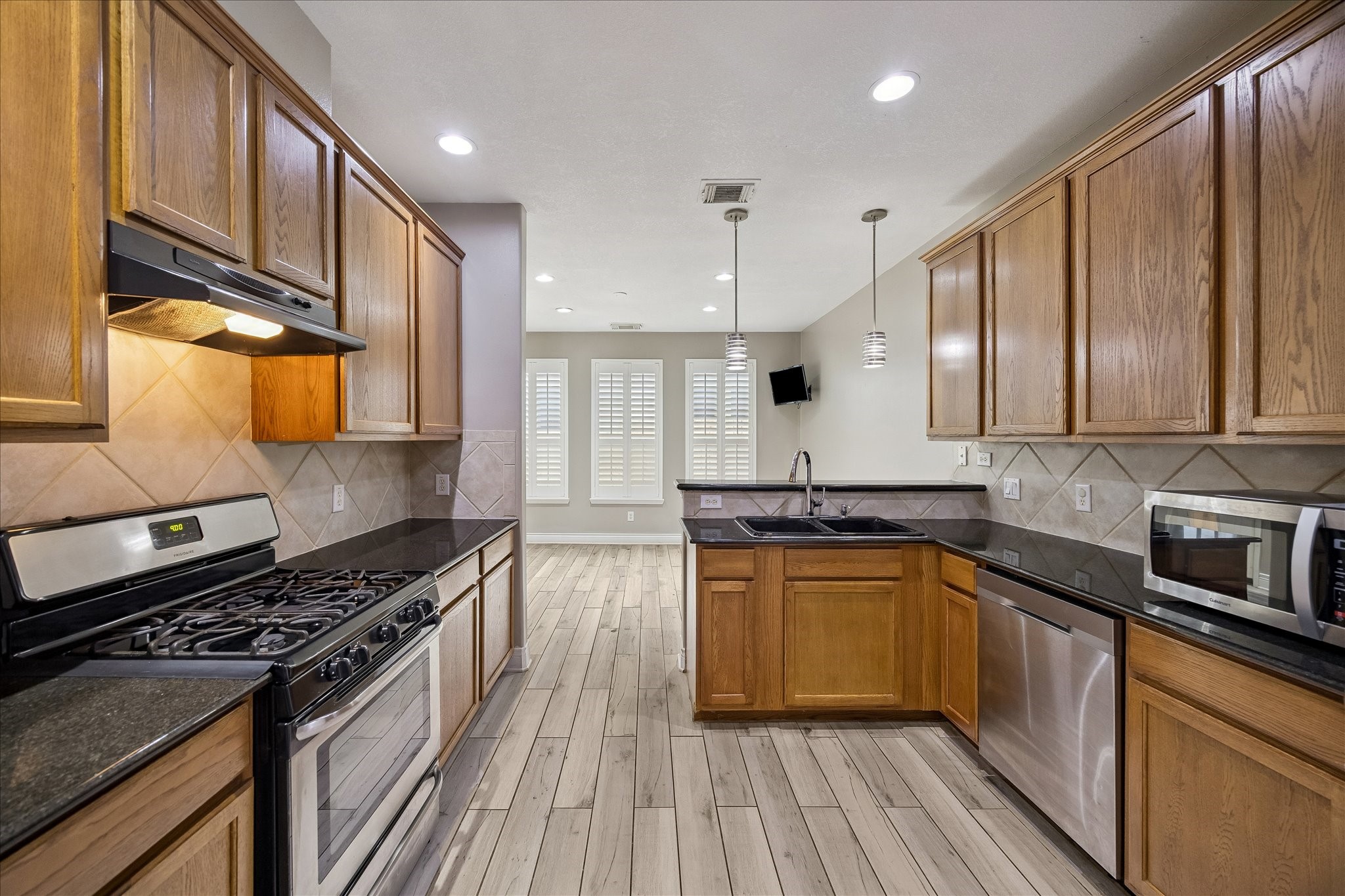 7403 Hollister Ridge Houston, TX 77040 - Photo 4 of 12 a kitchen with stainless steel appliances granite countertop hardwood floor sink stove and granite counter top